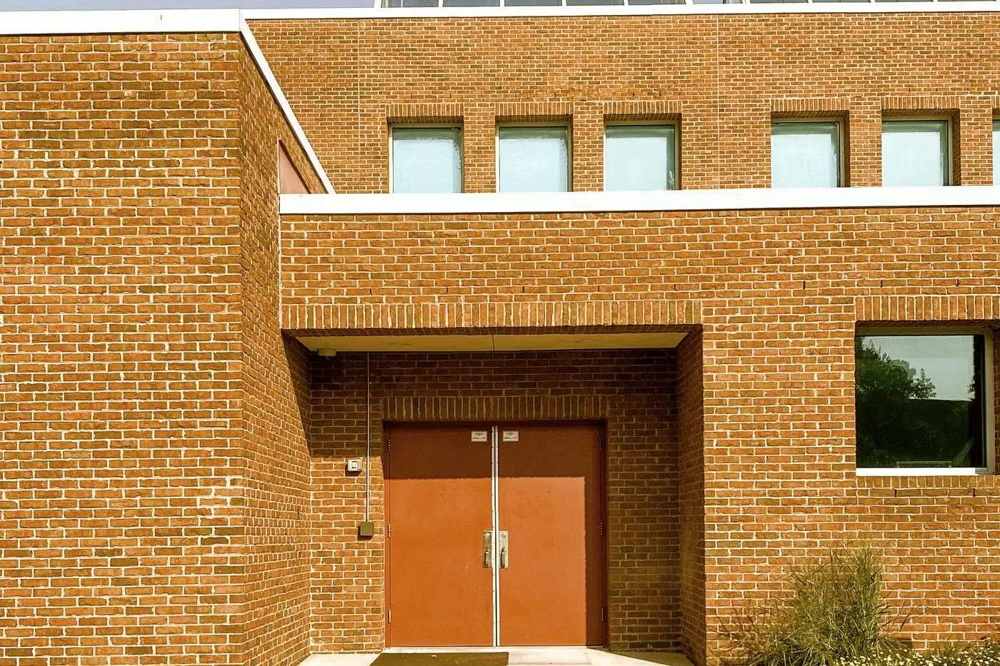 The entrance of a modern brick school building