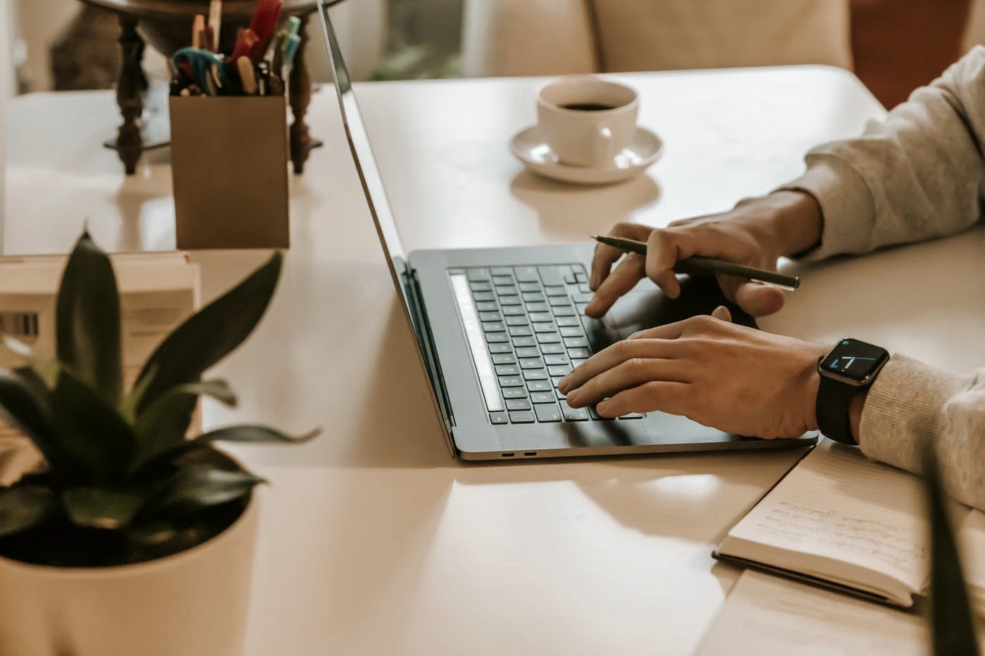 A person typing on a laptop at a tidy desk